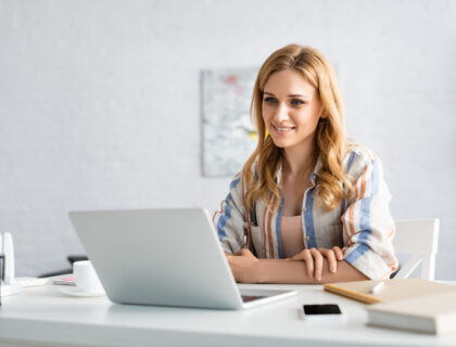 Młoda kobieta pracująca przy biurku na laptopie