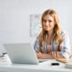 Młoda kobieta pracująca przy biurku na laptopie